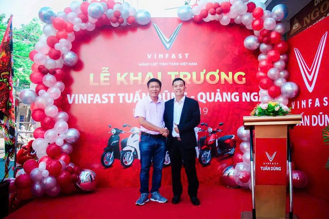Bắt tay chúc mừng trước phông khai trương